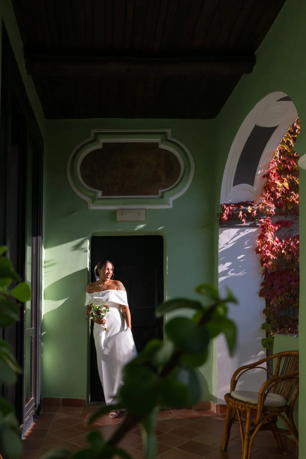 Bride beside a balcony in a green-walled room