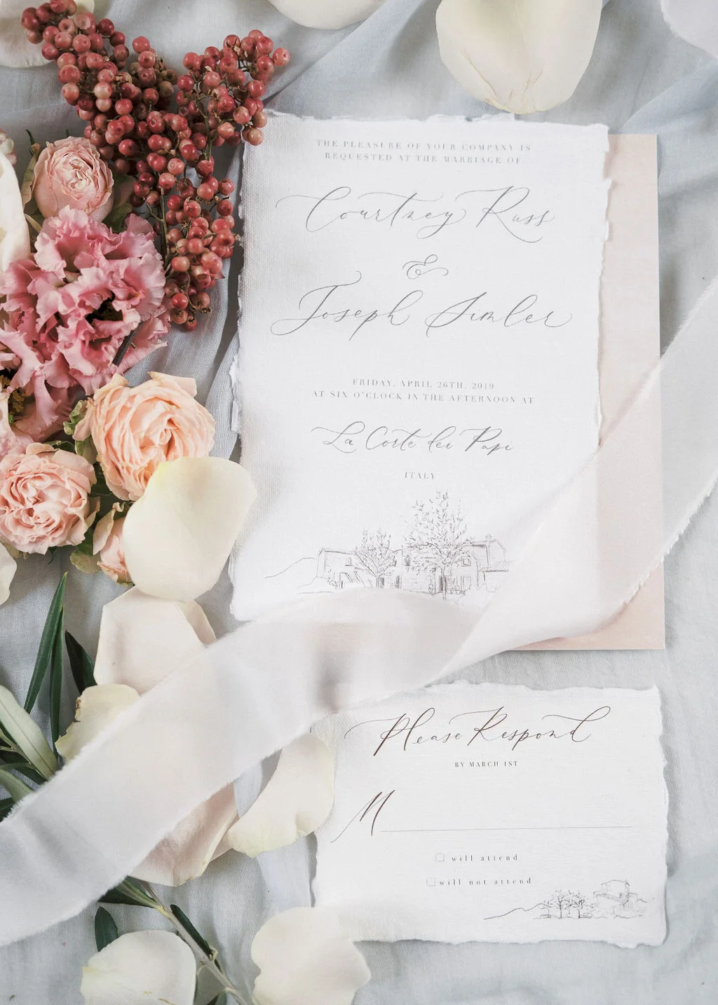 Wedding stationery beside pink flowers