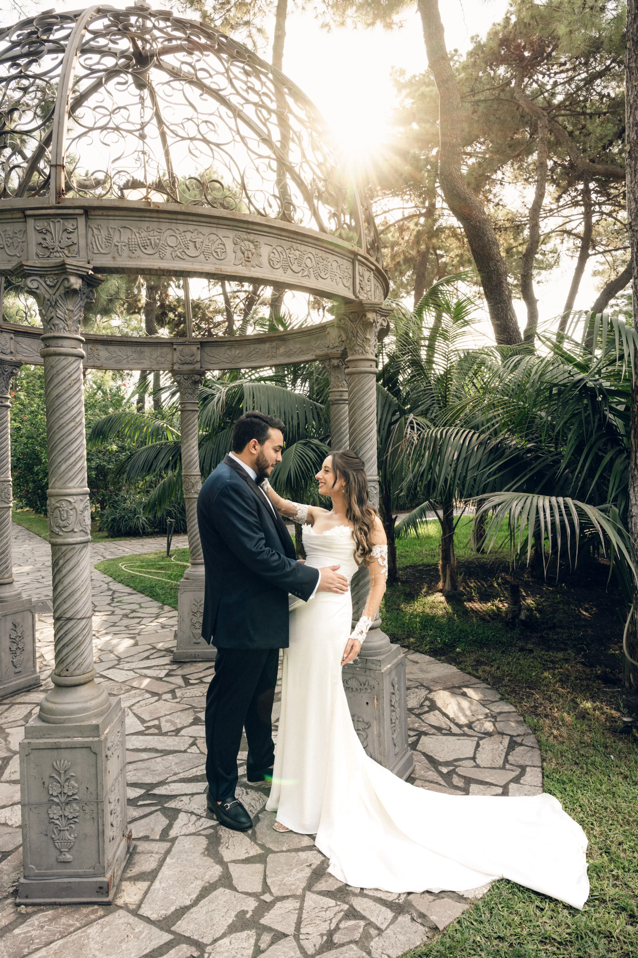 Bride and groom beneath a circular stone pavilion
