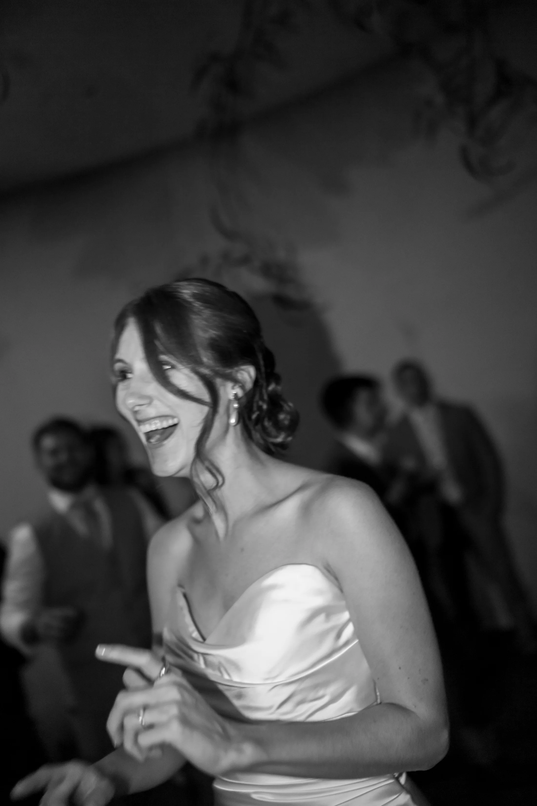 Black-and-white photograph of a bride laughing