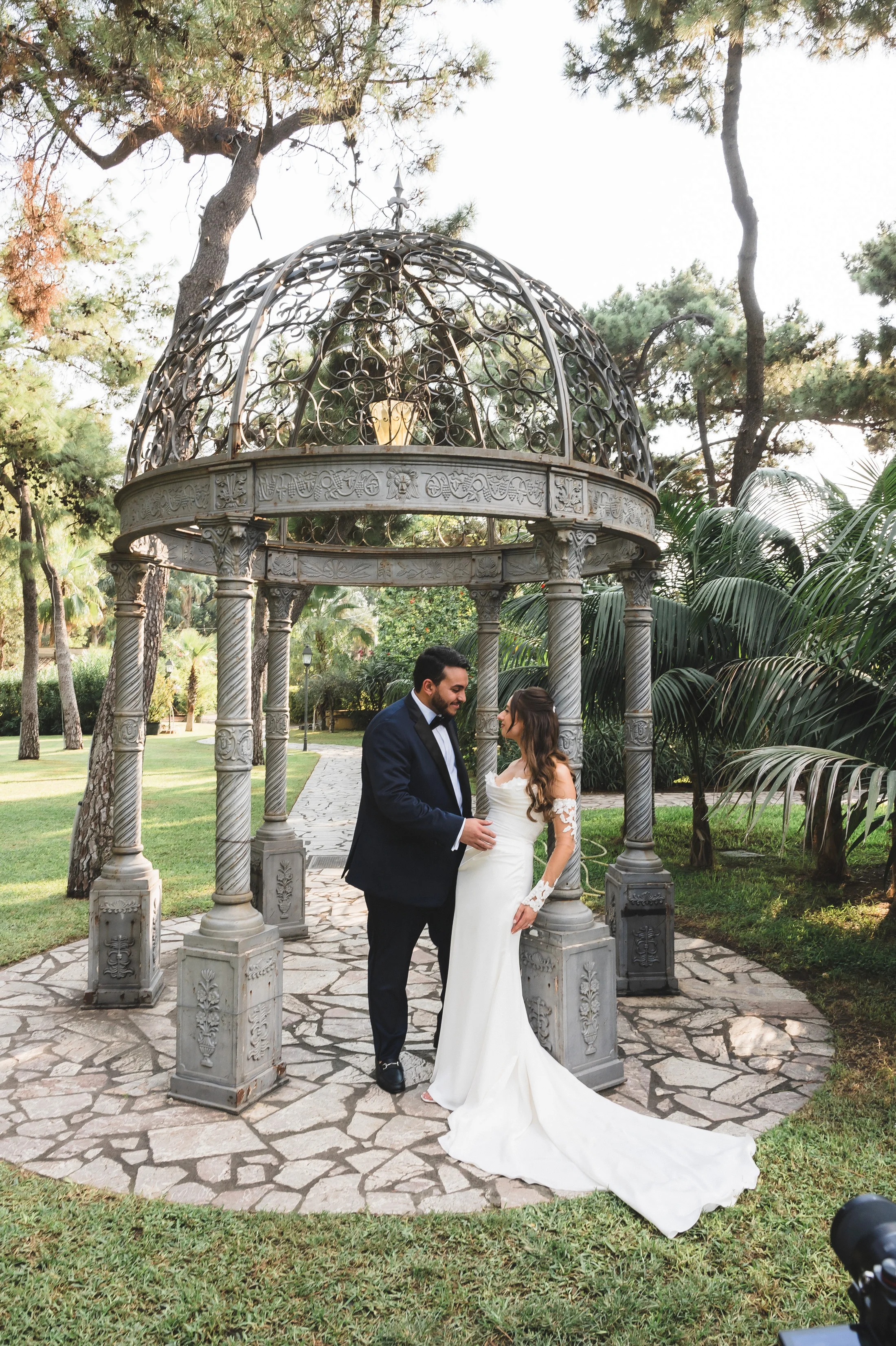 Bride and groom at a circular garden pavilion