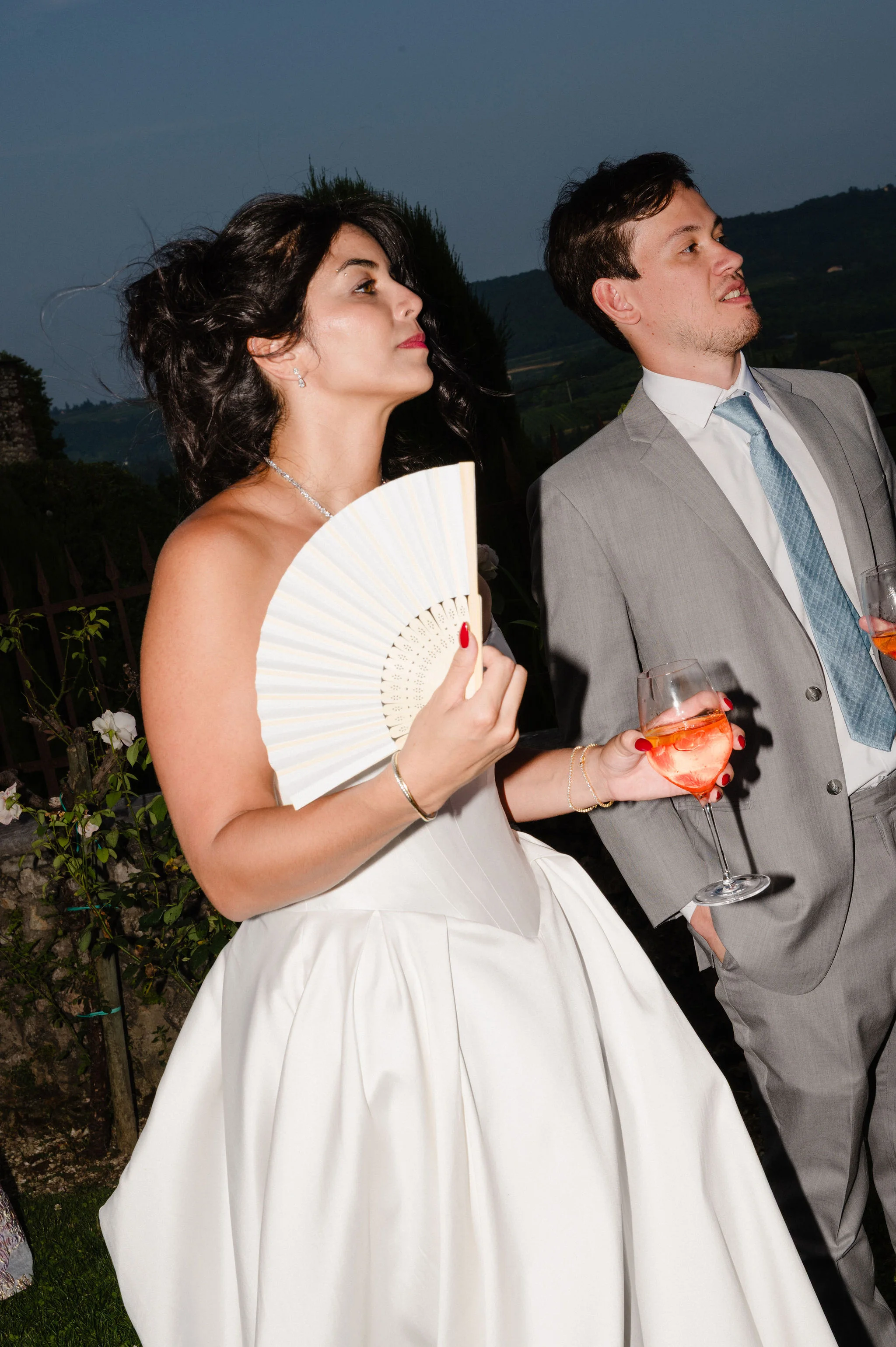 Bride and groom holding drinks at the reception