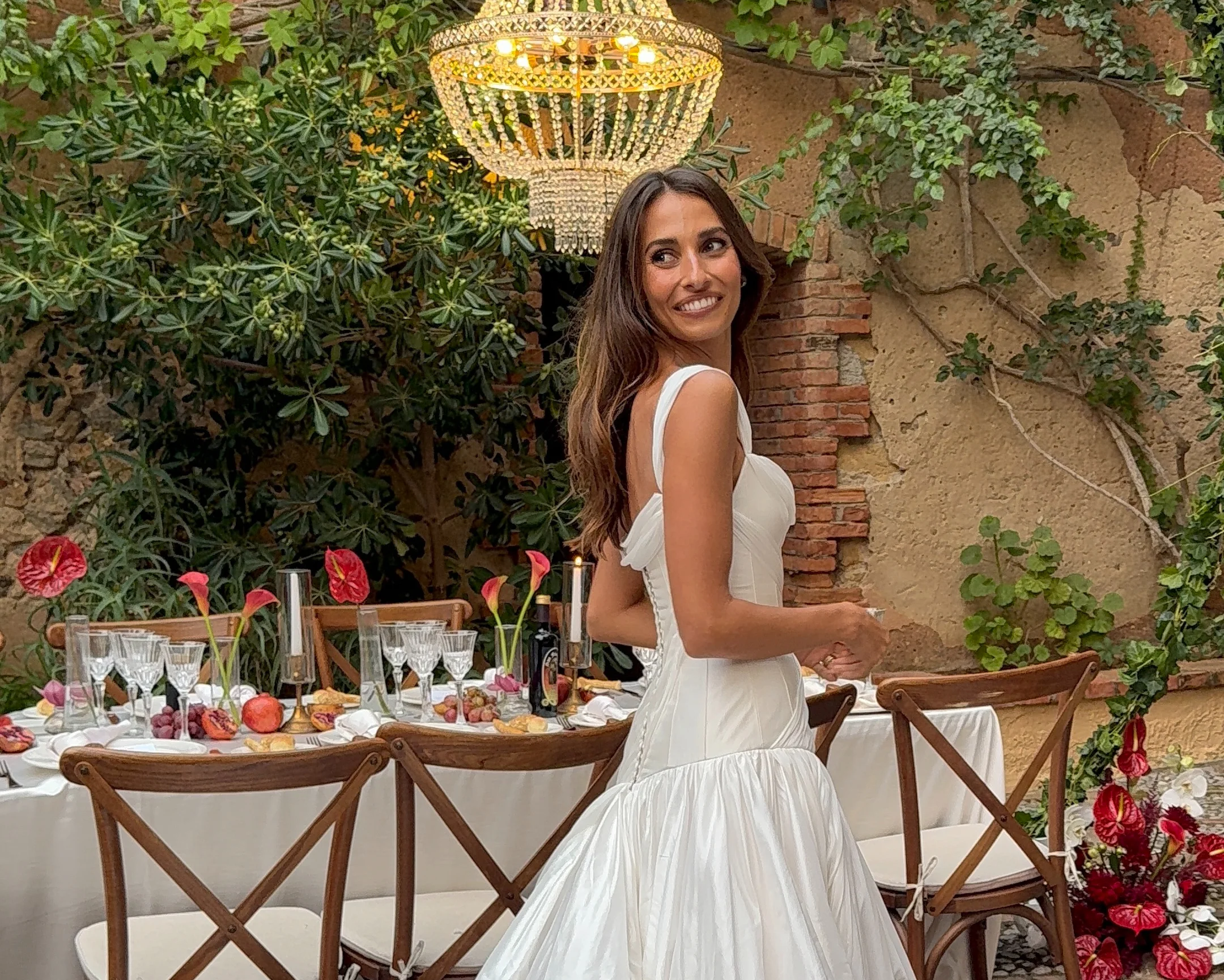 Bride seated beside a reception table in a garden