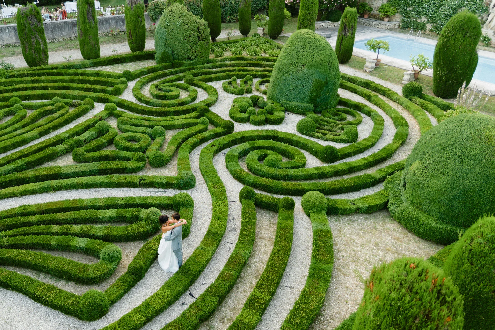 Bride and groom in a formal hedge garden