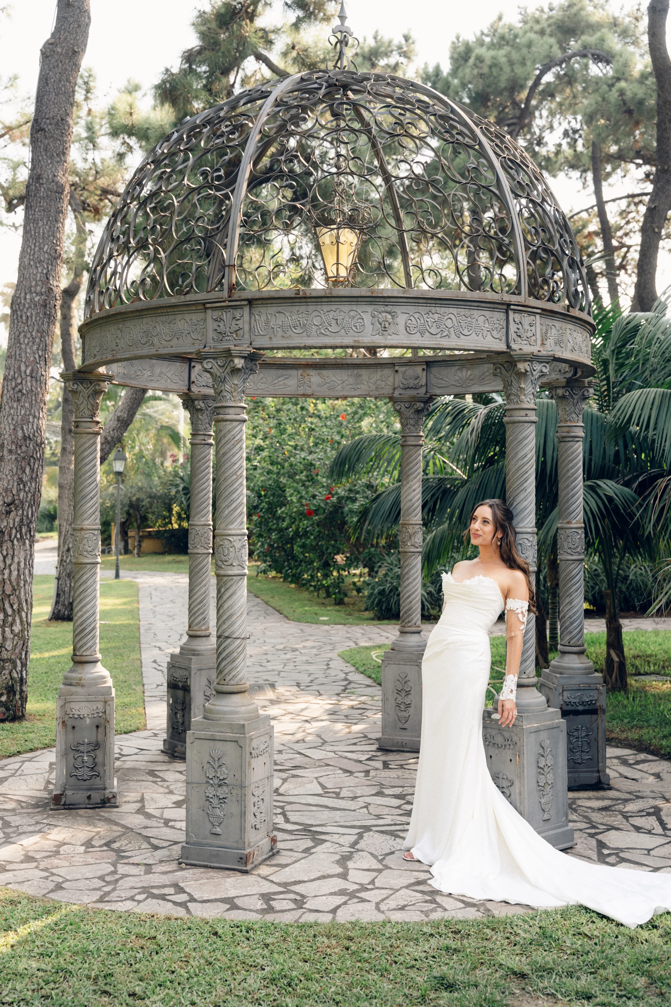 Bride beneath a circular stone garden pavilion