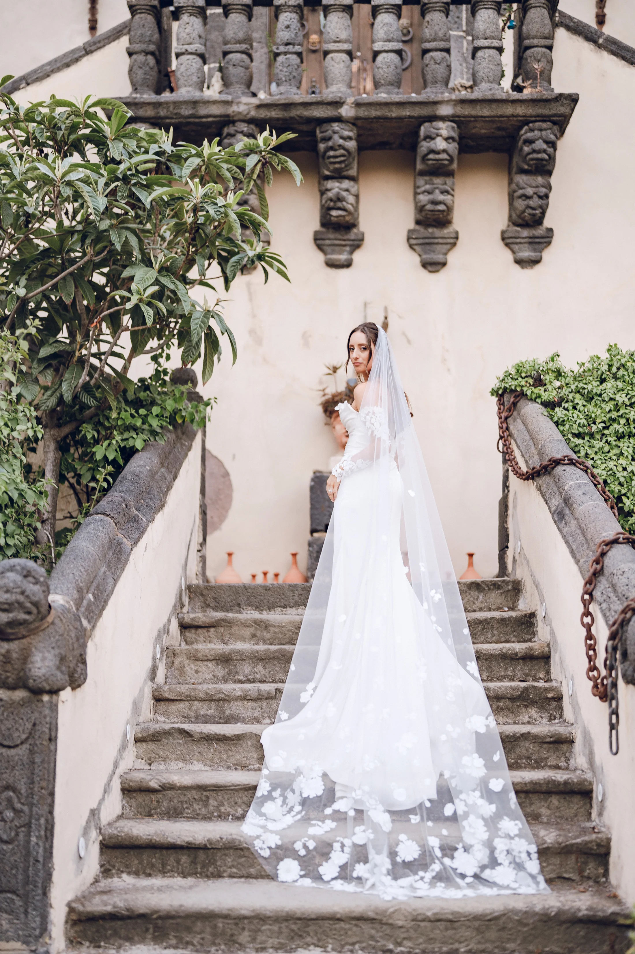 Bride on a stone staircase outside a villa