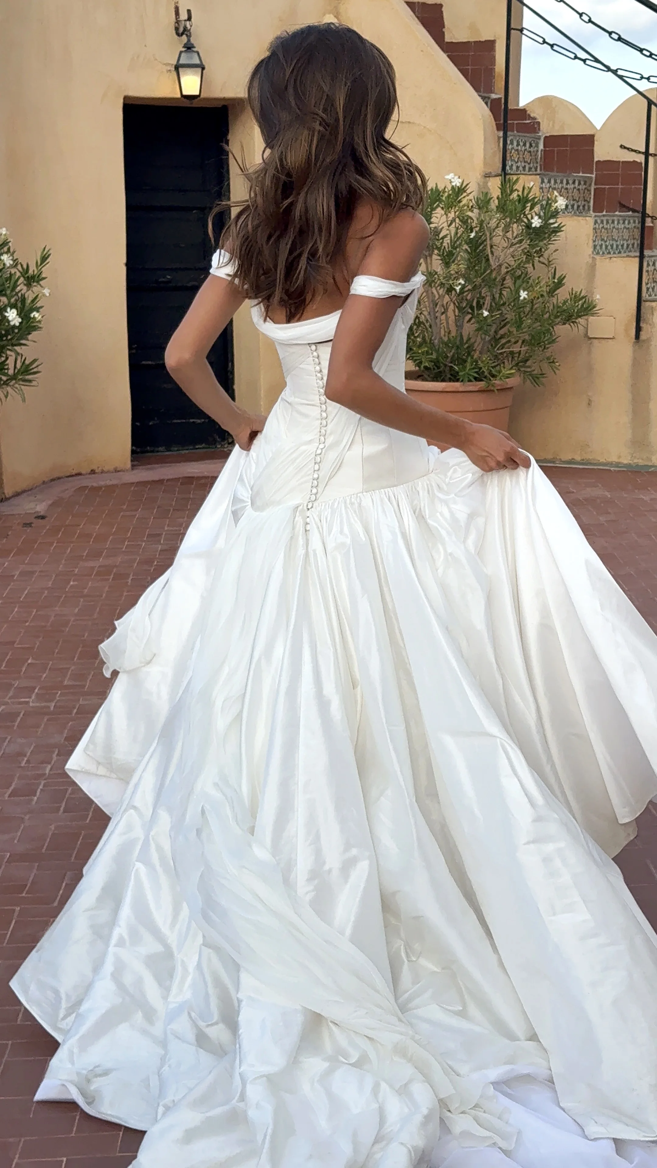 Bride holding her dress on an outdoor staircase