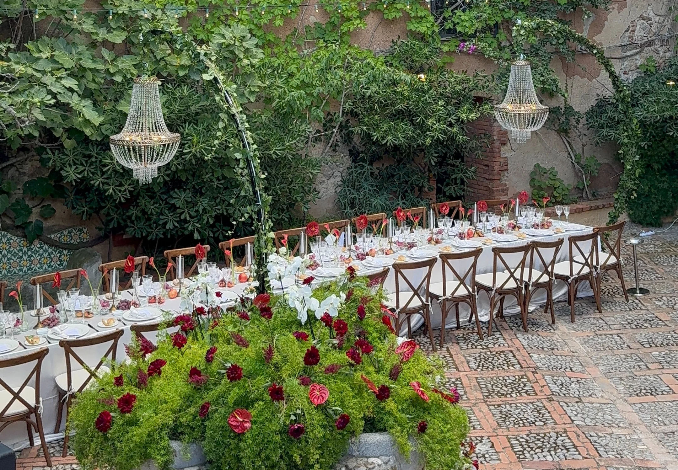 Long reception table in a leafy courtyard