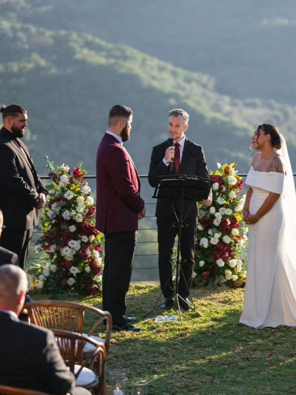 Bride and groom exchanging vows with a countryside view