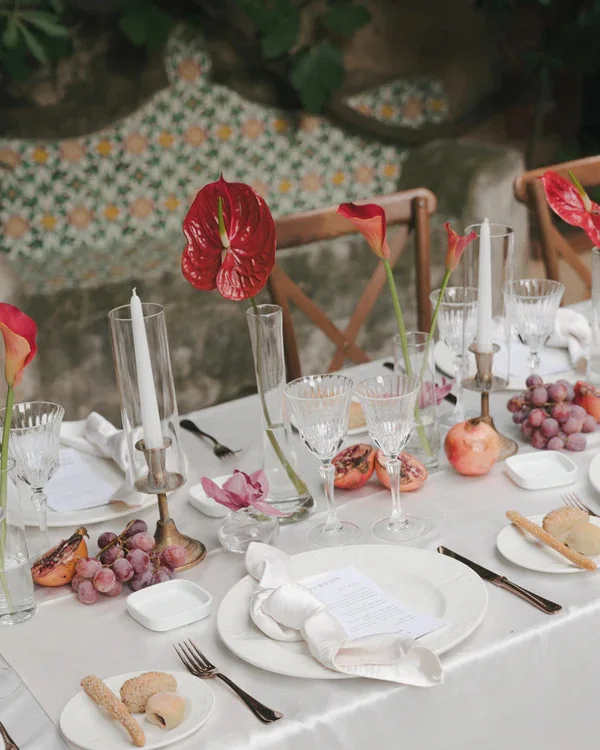 Reception place setting with red flowers and green fruit