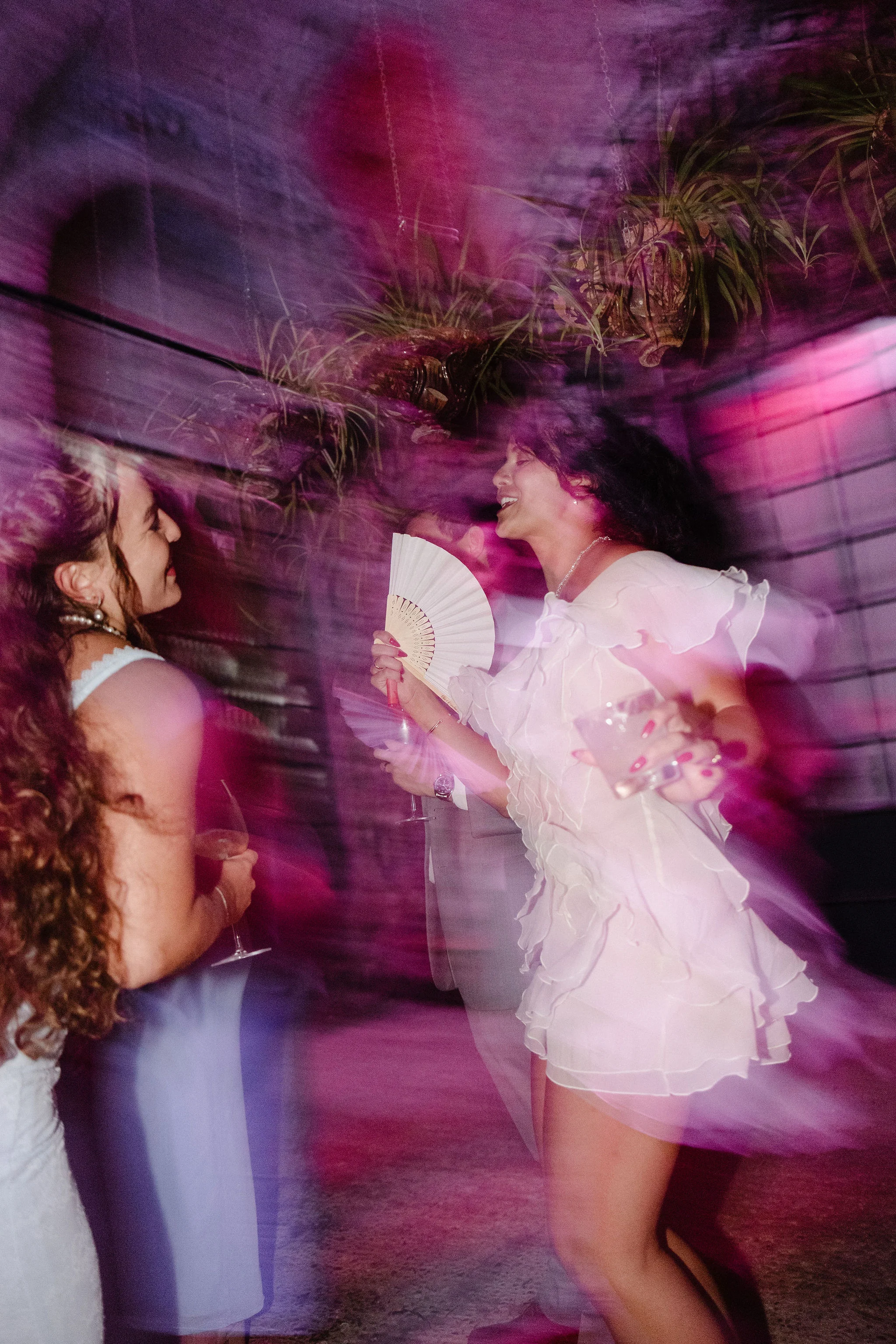 Bride dancing under coloured lights