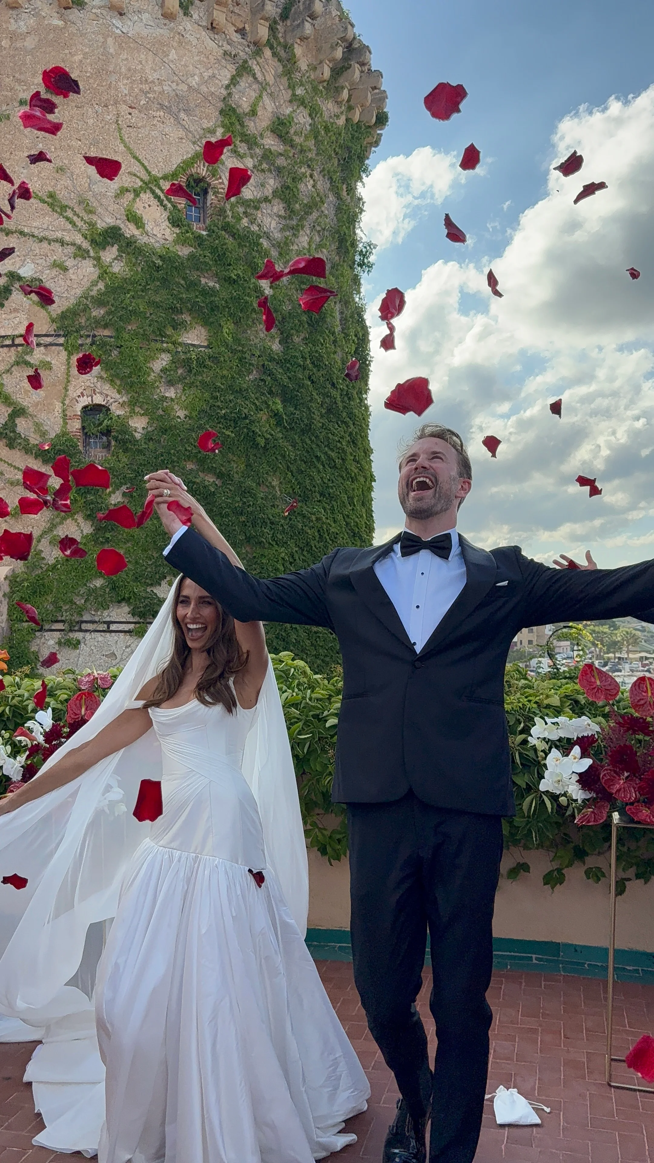 Bride and groom walking through falling confetti