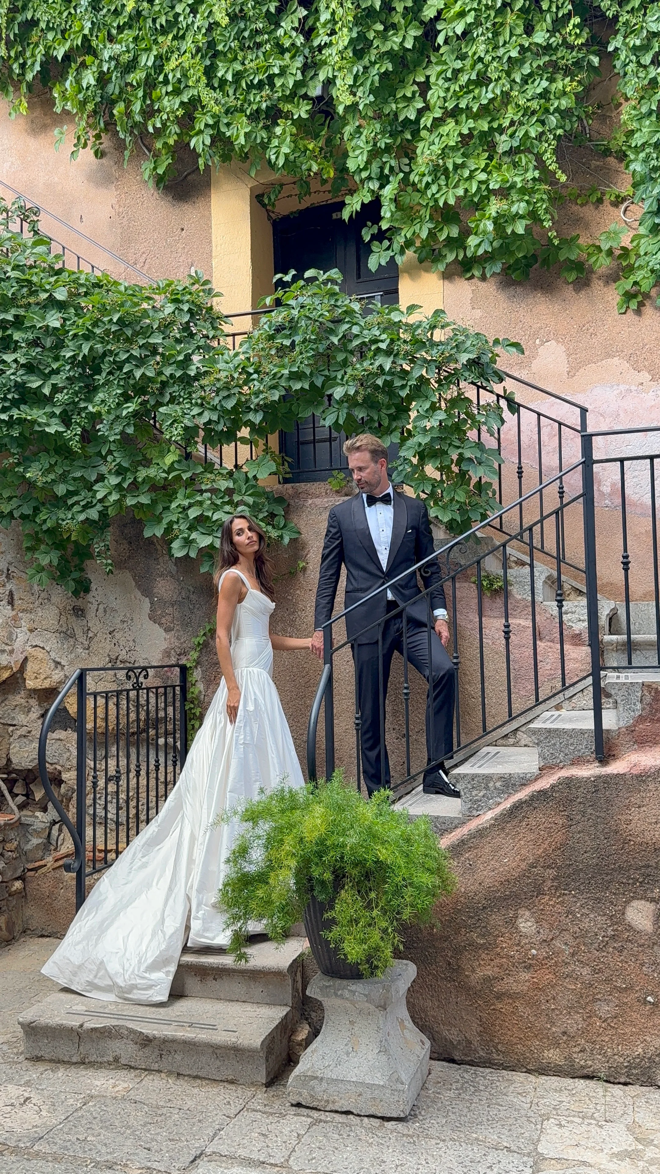 Bride and groom walking down garden steps