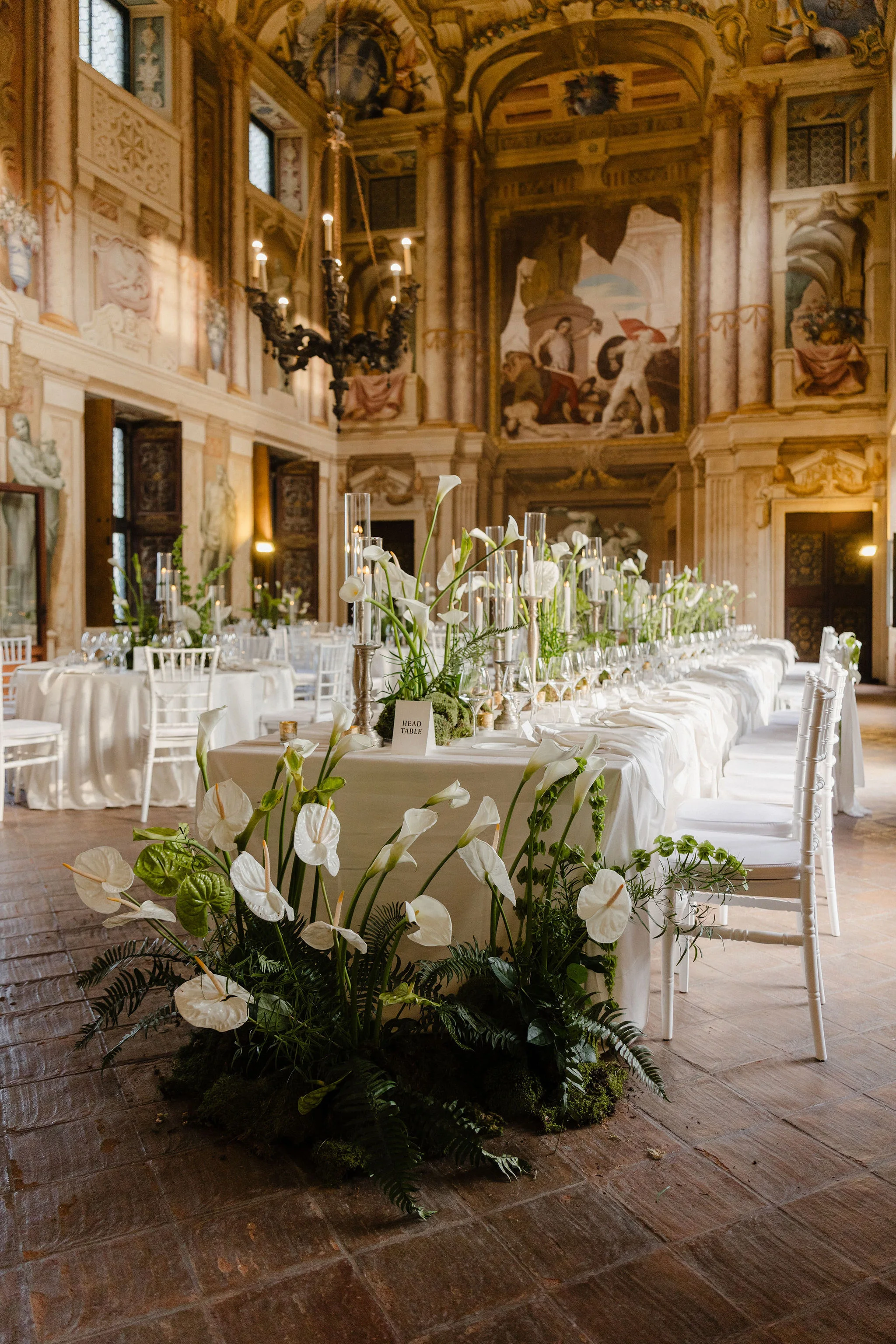 Wedding reception table beneath chandeliers