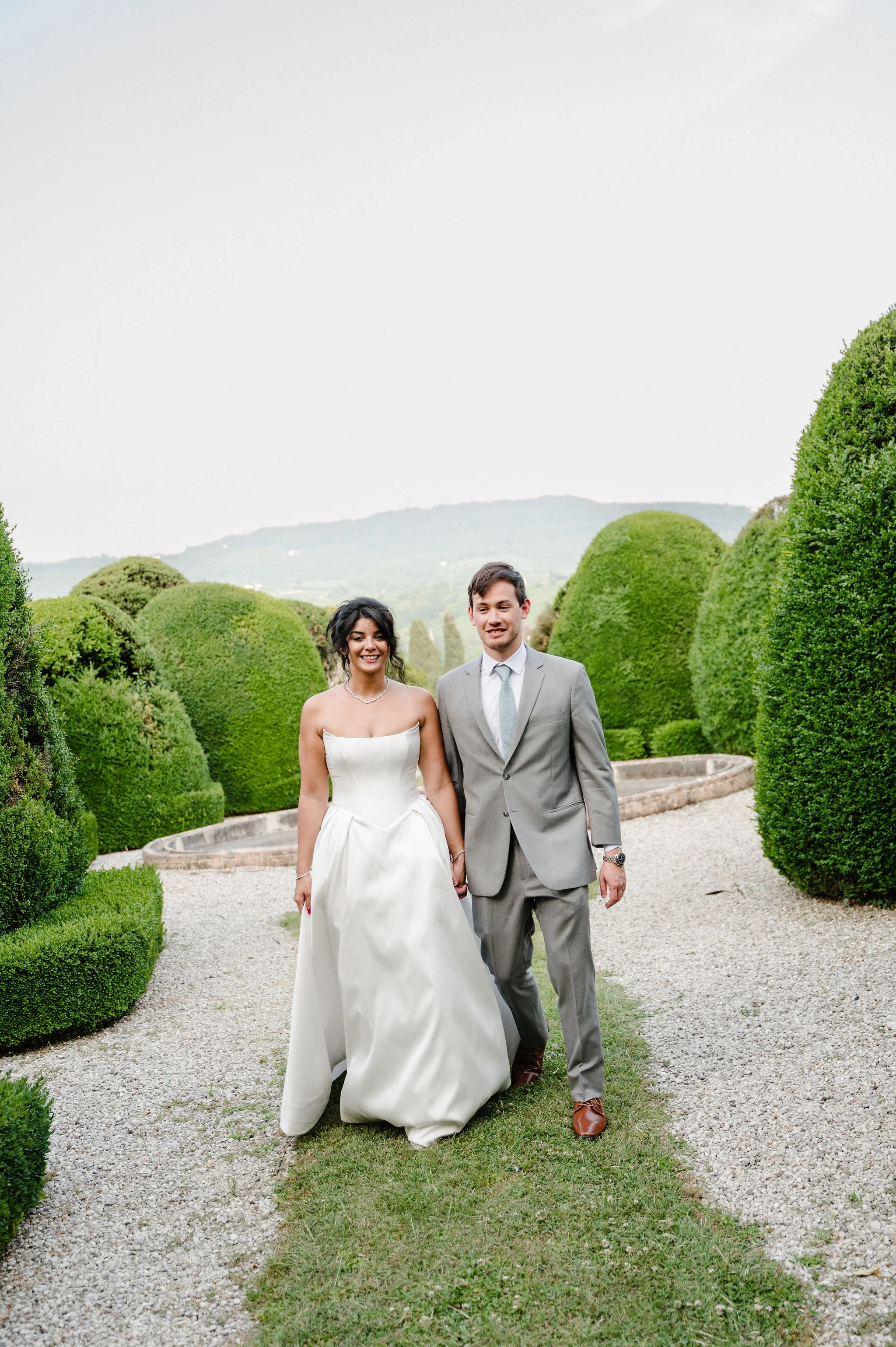 Bride and groom seated in a formal garden