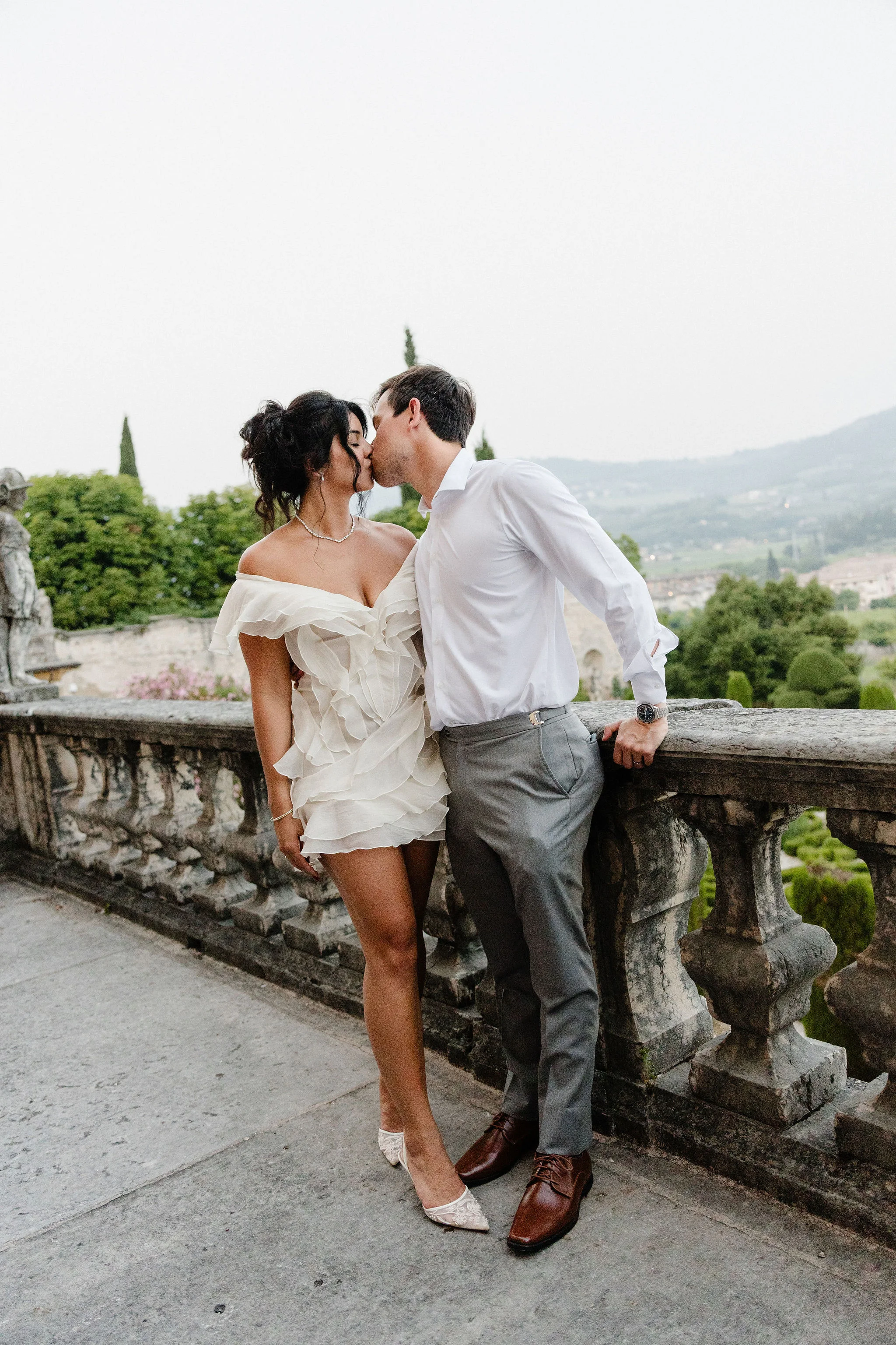 Bride and groom sitting together on a stone terrace