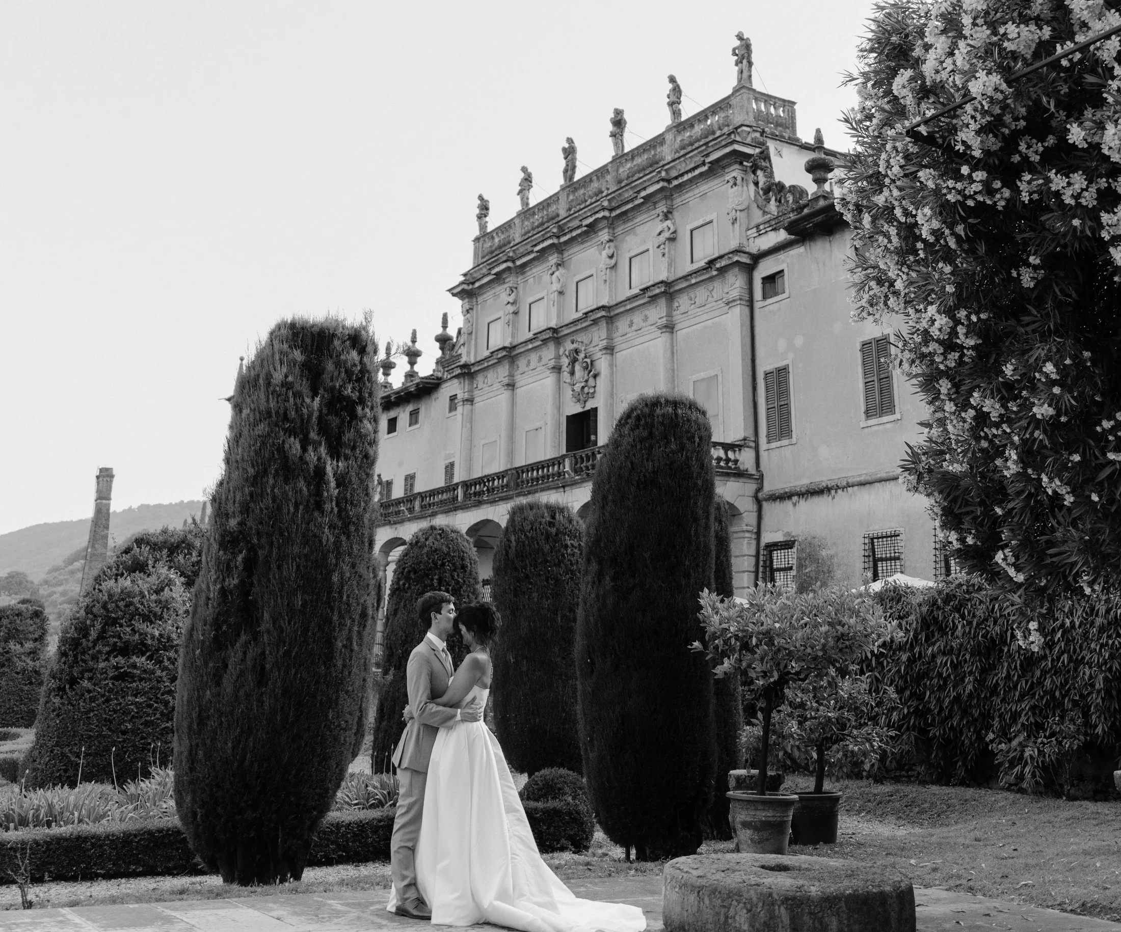Black-and-white view of a bride outside a villa