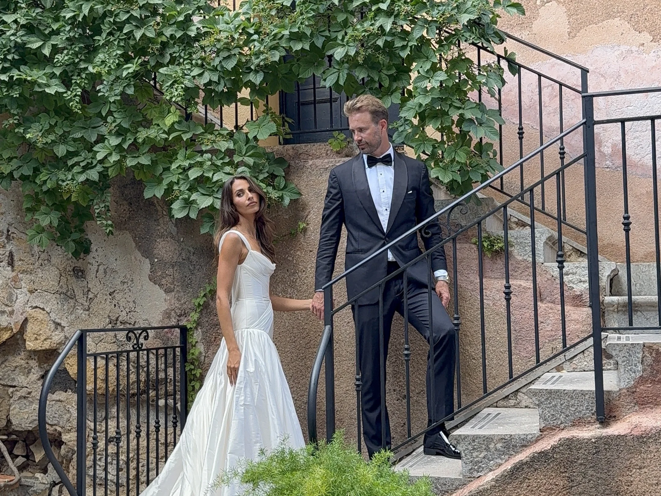Bride and groom standing on garden steps