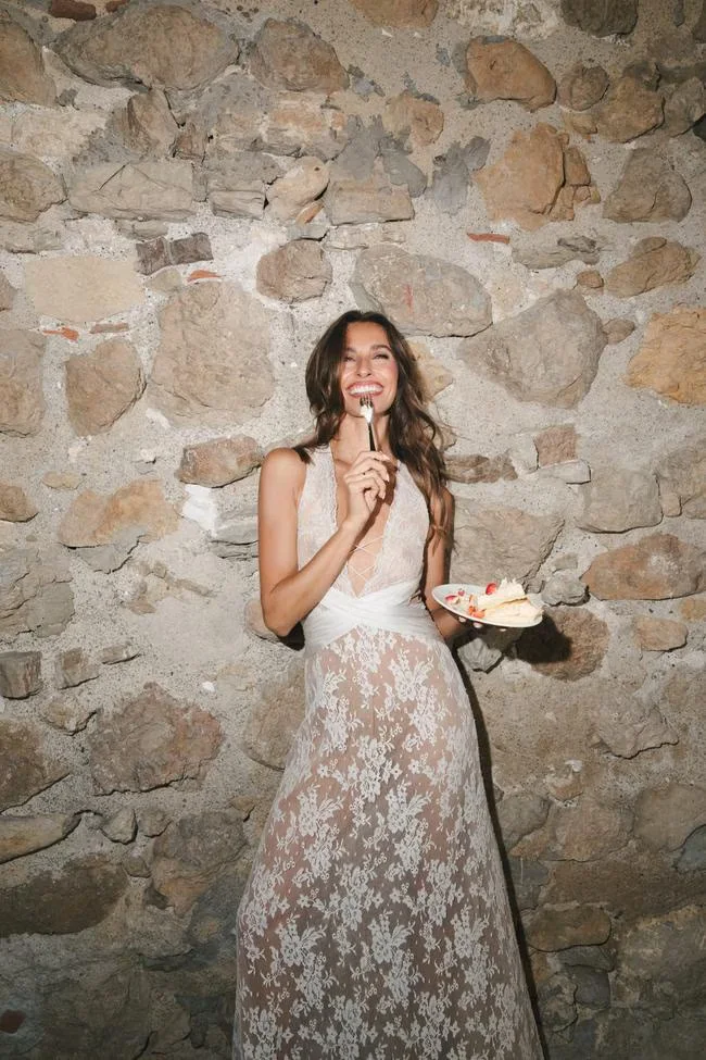 Bride in an evening dress against a stone wall