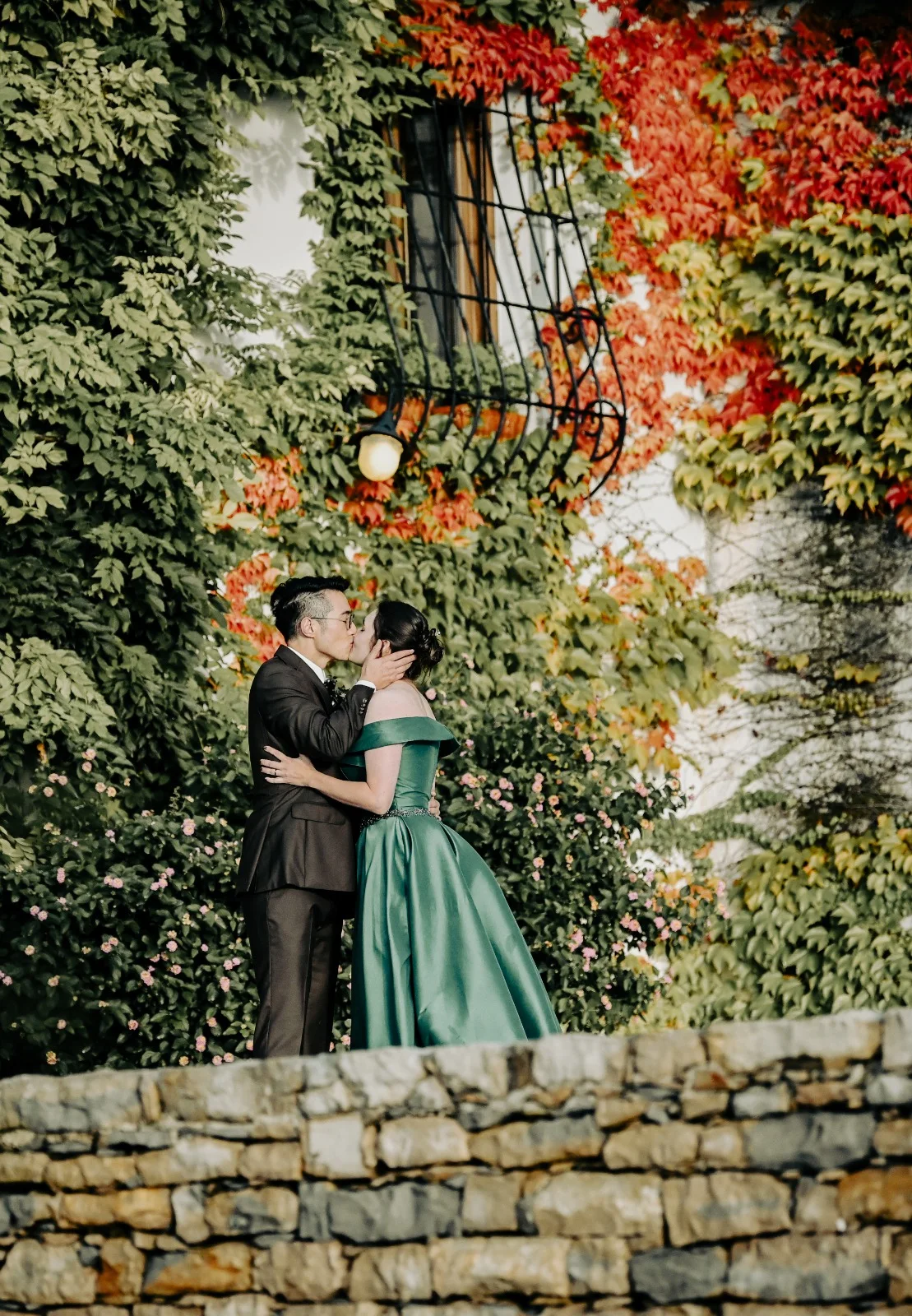 Couple standing on a leafy stone staircase