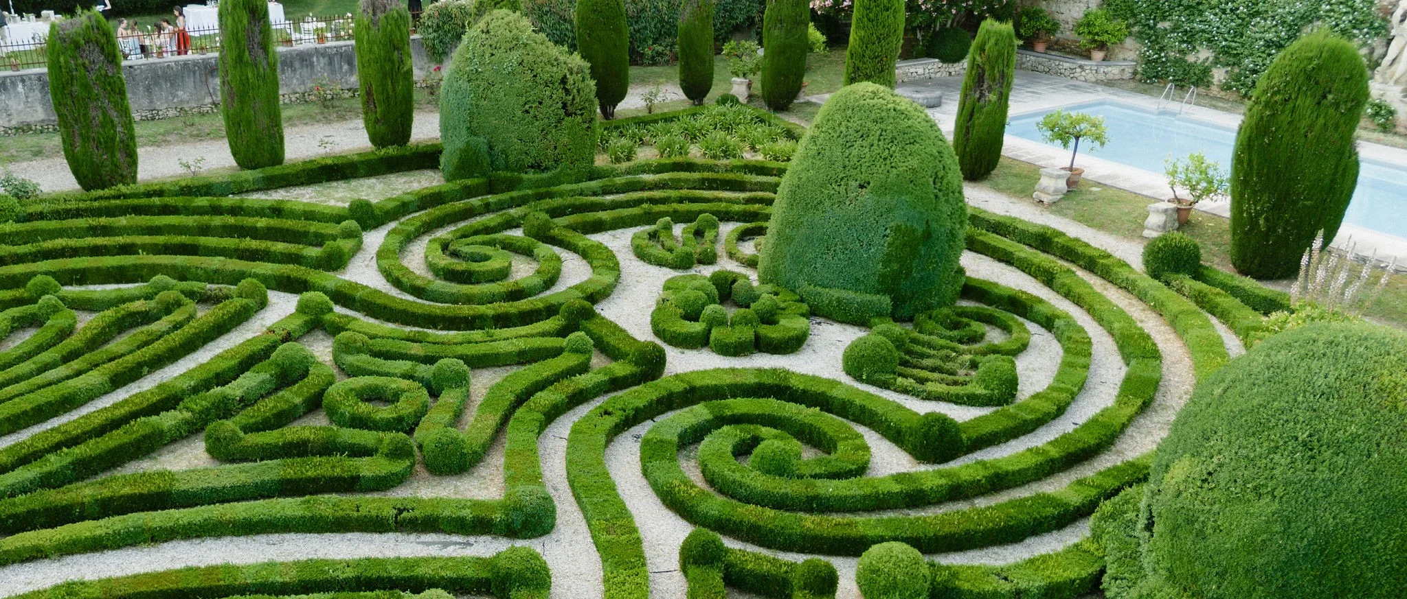 Bride and groom in a formal hedge garden
