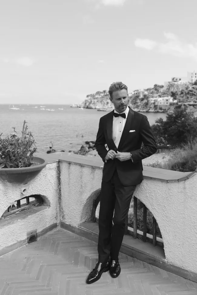Black-and-white portrait of a groom on a terrace