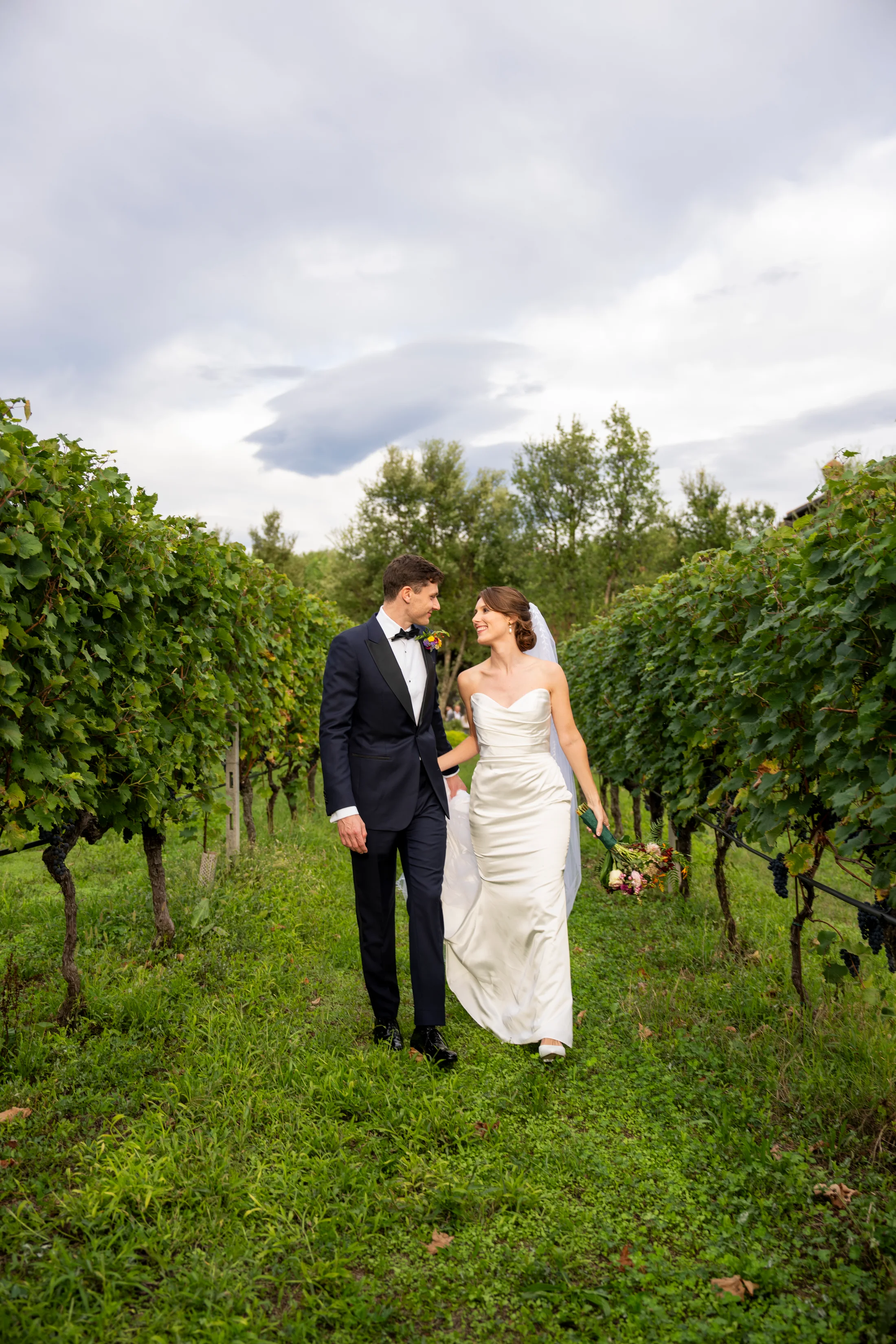 Bride and groom standing in a vineyard