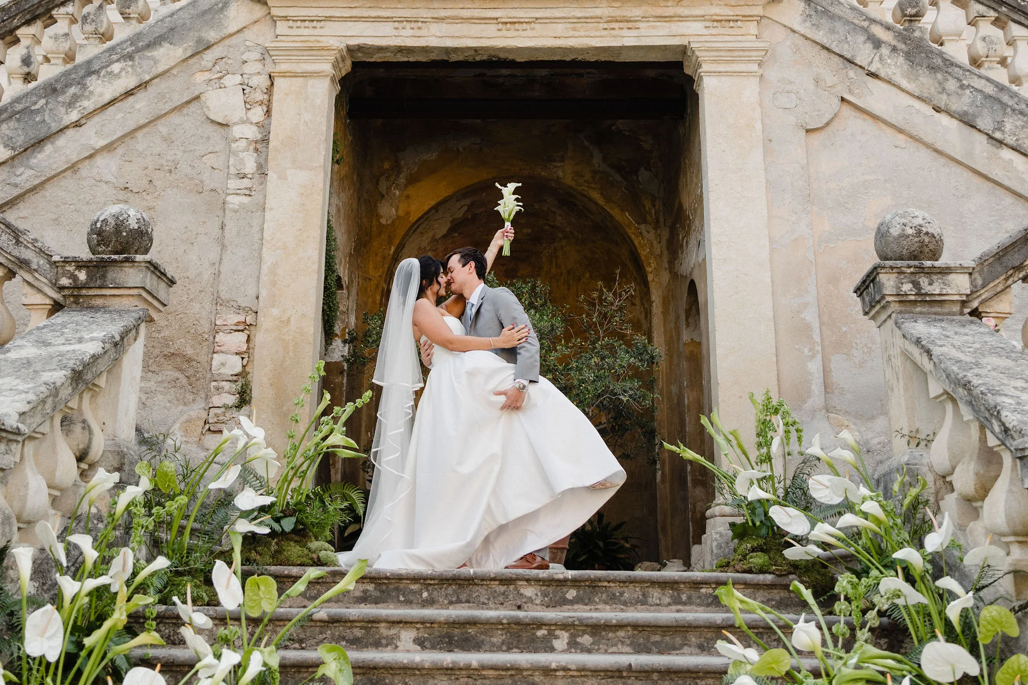 Bride and groom on an ornate stone staircase