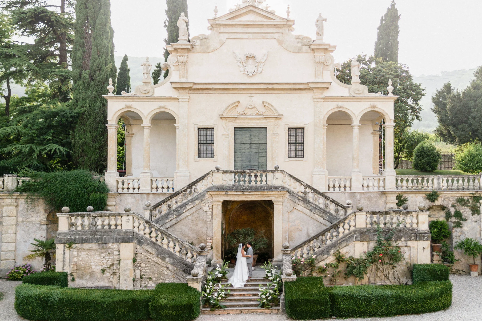 Ornate villa façade and staircase framed by trees