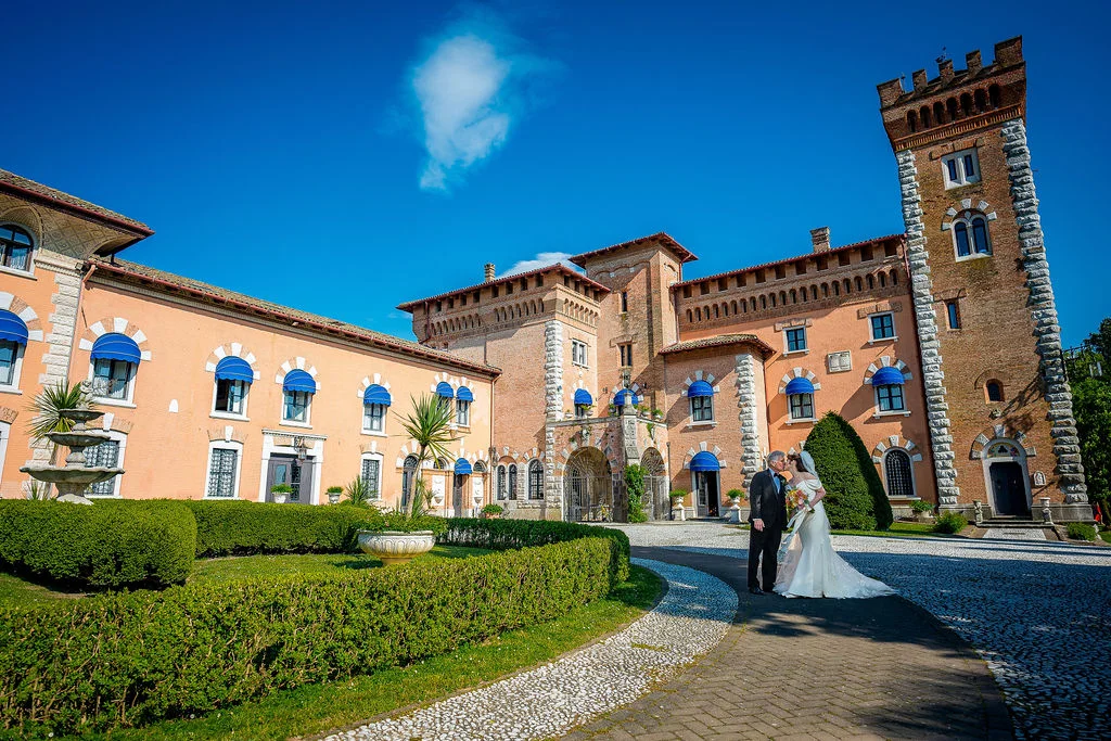 Bride and groom in front of a brick castle