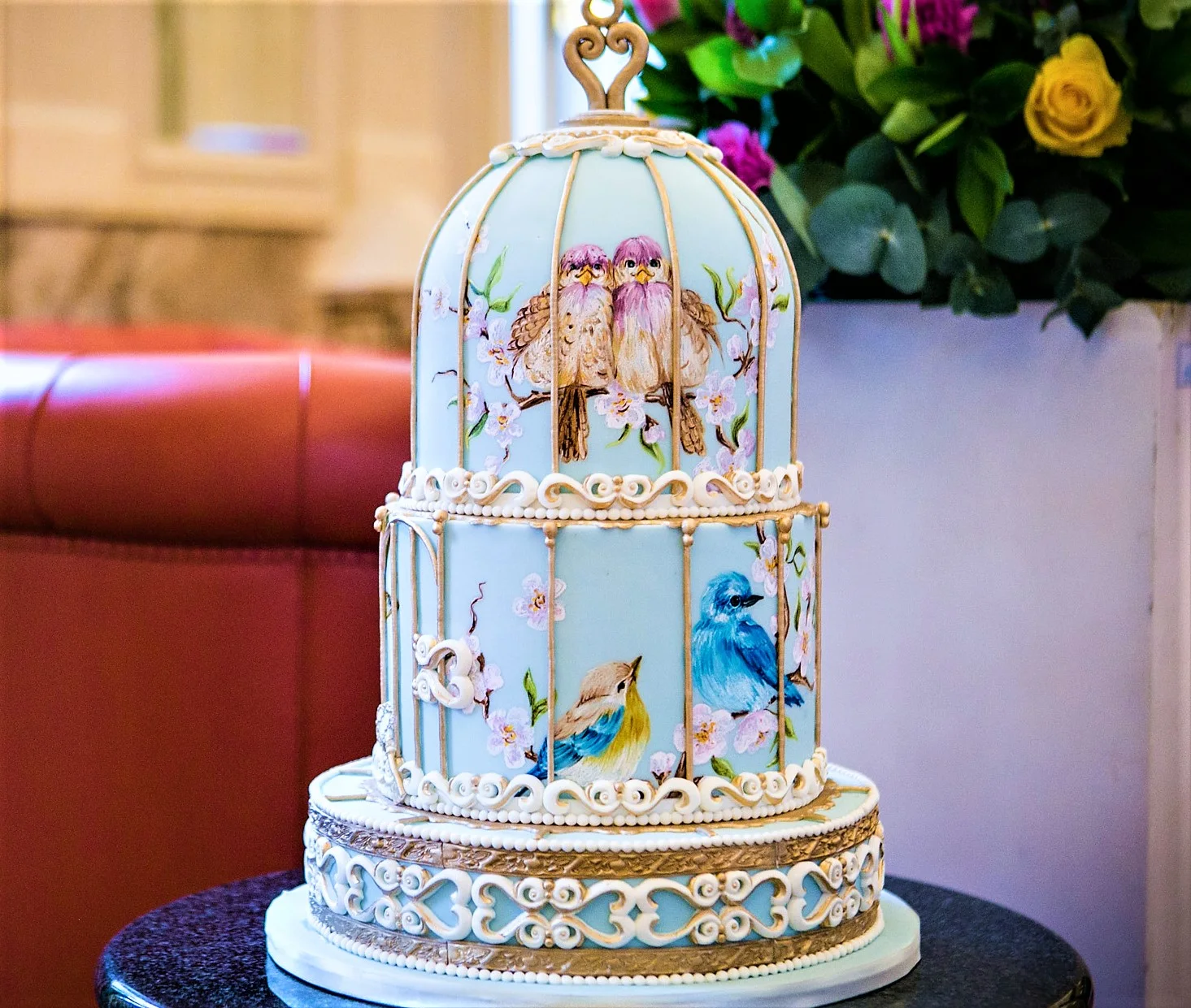 Tiered wedding cake decorated with birds and flowers